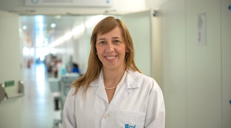 médica cirurgiã no corredor do hospital a sorrir e a olhar para a câmara