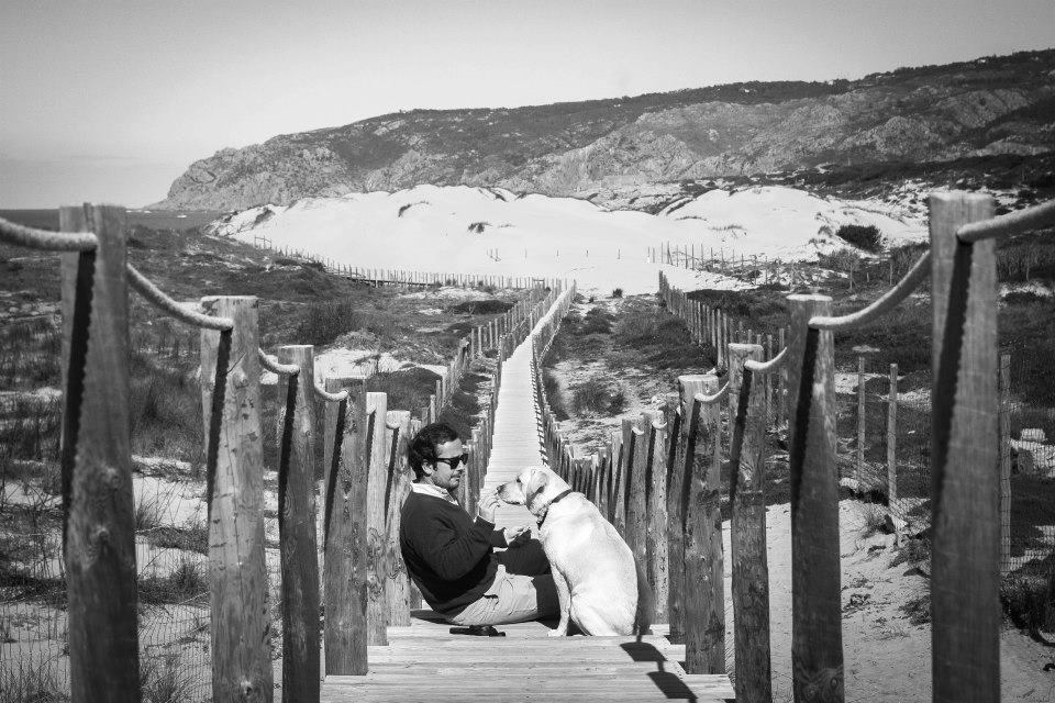 jovem com cão na praia