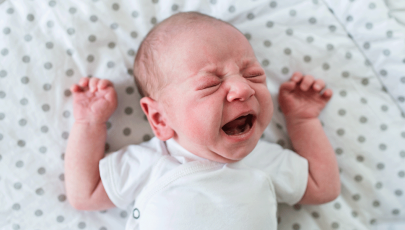 Criança chora devido a cólicas no bebé