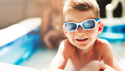 Criança a usar óculos de sol na piscina