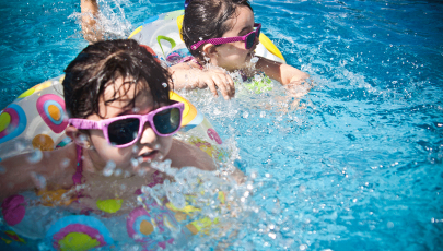 Crianças na piscina do seu destino de férias