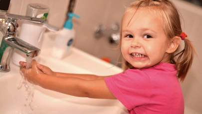 Menina cumpre a ordem dos pais de lavar as mãos