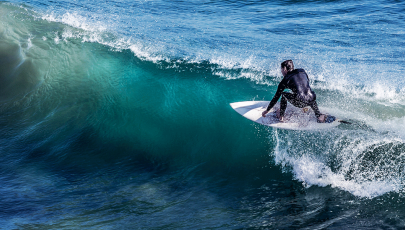 homem a fazer surf exposto a condições propícias a provocar otite do surfista