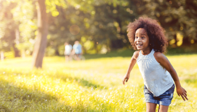 Criança com sinéquia dos pequenos lábios corre no parque