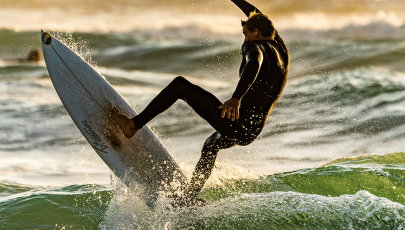 homem a fazer surf de após aprender a prevenir lesões