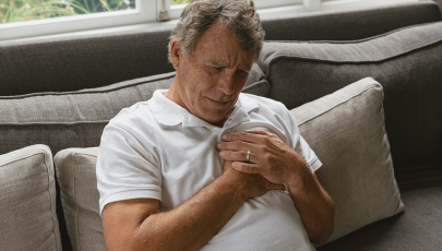 Indivíduo afetado por cancro da mama no homem leva mãos ao peito