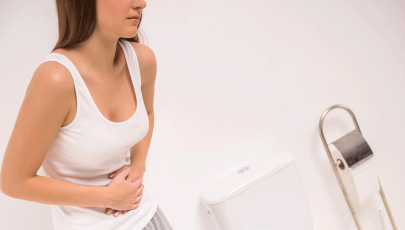 Mulher com dores pondera formas de prevenir as hemorroidas