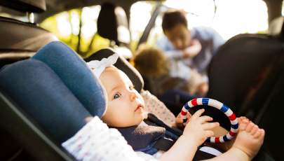 Bebé em cadeira de automóvel que segue normas de segurança de transporte de crianças