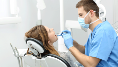 Mulher no dentista para avaliação da sua mucosite oral