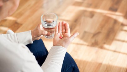 Doentes reumatológicos e COVID-19: pessoa toma a sua medicação