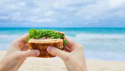 Indivíduo faz refeições saudáveis na praia