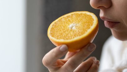 Pessoa cheira laranja para diagnosticar perda de paladar e de olfato