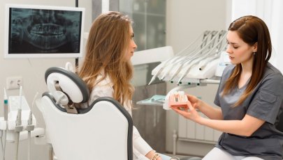 Mulher em consulta com médico dentista a ver soluções de implantes dentários