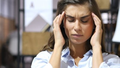 Mulher com dores de cabeça provocadas por disfunção temporomandibular