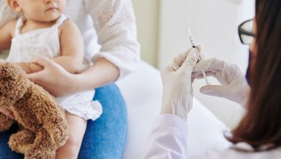 Médica administra vacina a bebé