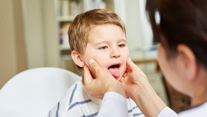 Criança com sintomas de escarlatina a ser avaliada por uma médica