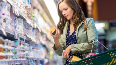 Mulher no supermercado avalia produtos diet e produtos light