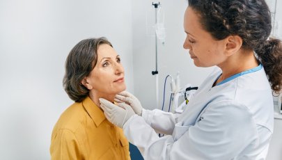 Médica examina paciente mulher para diagnóstico de doenças da tiroide