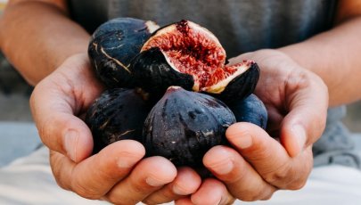 Mãos a segurar fruta, neste caso figos.