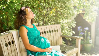 mulher grávida sentada num banco de jardim