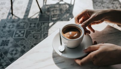 Pessoa a pegar em chávena com café