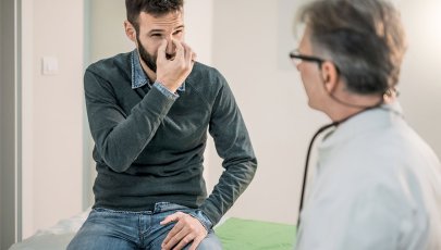 Homem com septo nasal desviado fala com médico sobre septoplastia