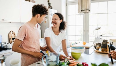 homem e mulher numa cozinha a preparar um snack saudável.