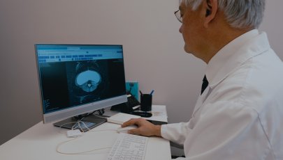 Médico sentado ao computador avaliar exame para diagnosticar doenças raras