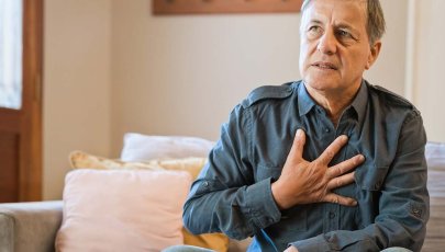 Homem com dor no peito leva a mão à zona do peito.