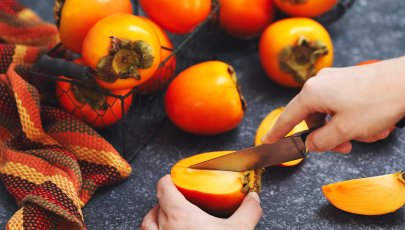 Pessoa corta dióspiros de roer.