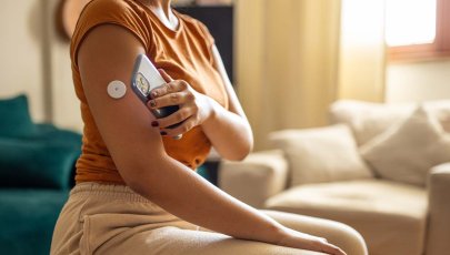 Mulher analisa níveis de glicose no sangue com recurso a dispositivos próprios.