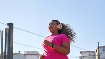 Mulher obesa corre na rua.