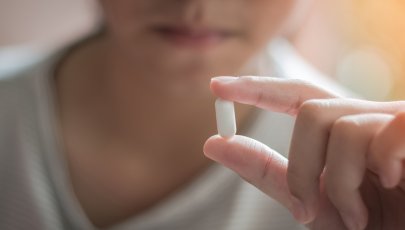 Pessoa toma comprimido de ibuprofeno