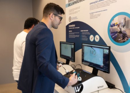 jovem rapaz a experimentar o simulador de cirurgia robótica na exposição dos 80 anos da CUF