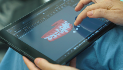Médica dentista mostra projeto de sorriso alinhado por alinhadores dentários em formato 3D num tablet.